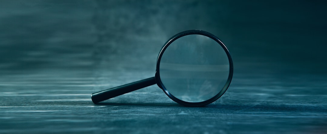 A magnifying glass rests on a textured surface.