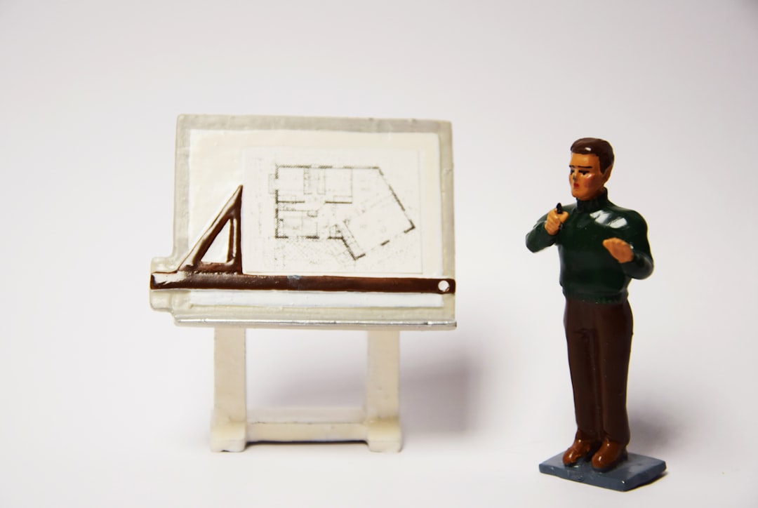 A figurine of a man standing next to a miniature easel